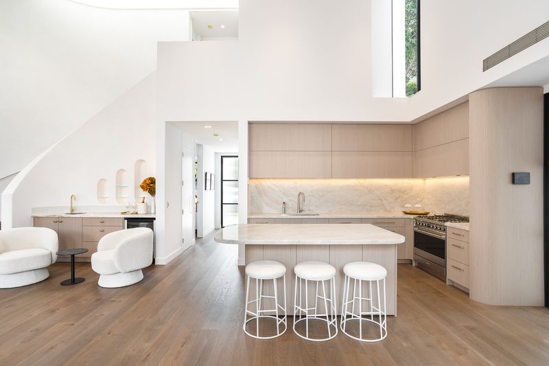 Pale timber kitchen with marble benchtop and concealed LED strip lighting under the overhead cabinetry