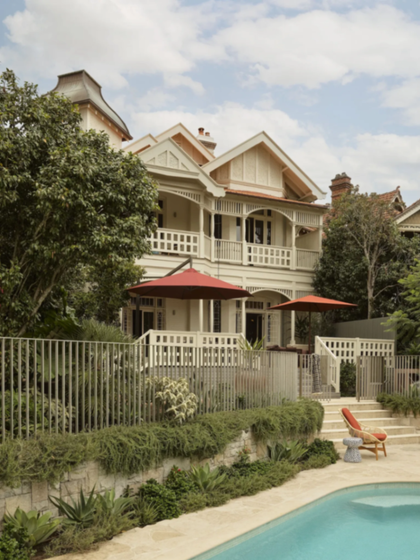 Heritage Darling Point residence with deep verandahs and gables seen across the pool and terraced garden