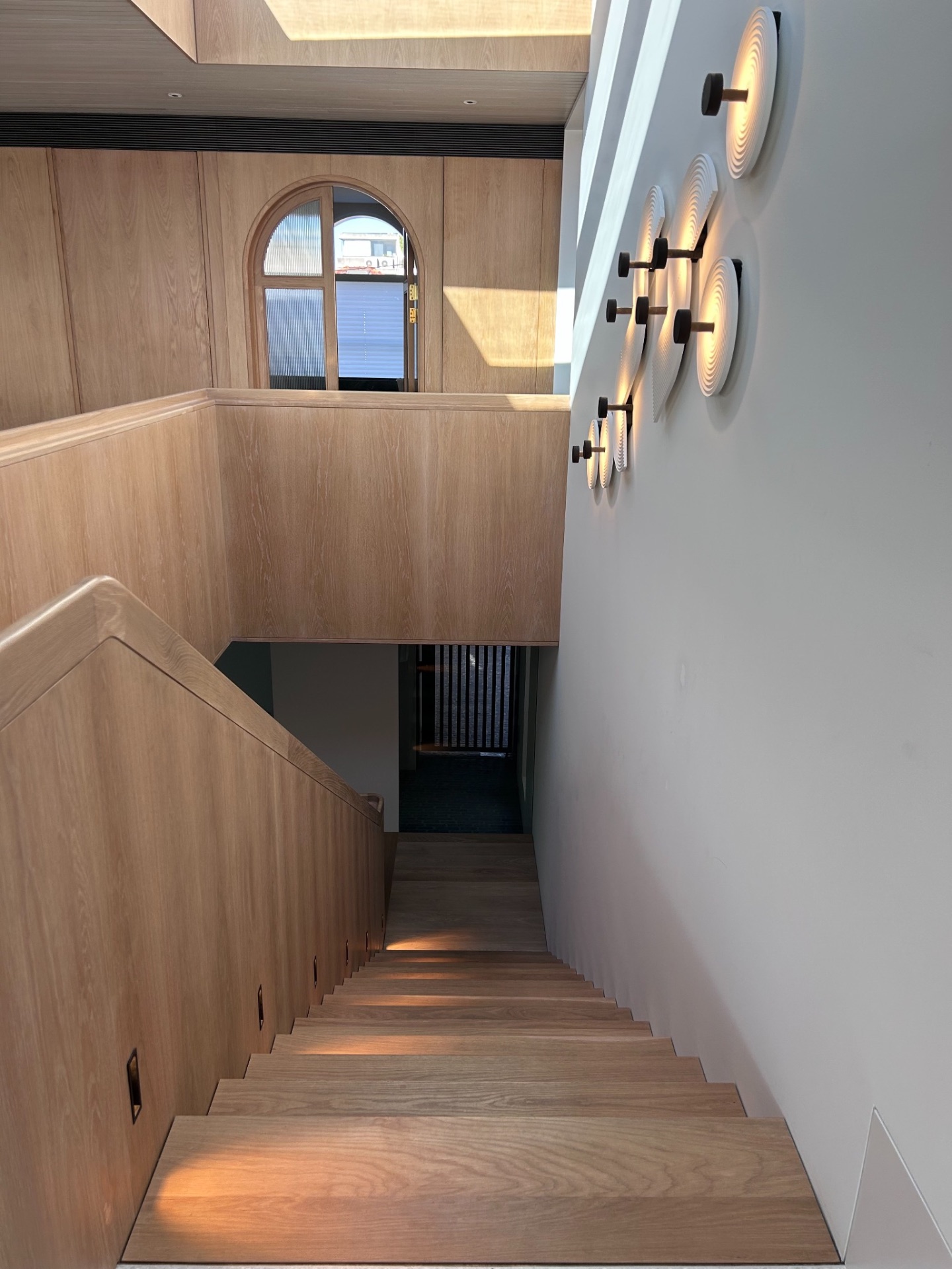 Stair with recessed step lights and a wall of sculptural illuminated discs